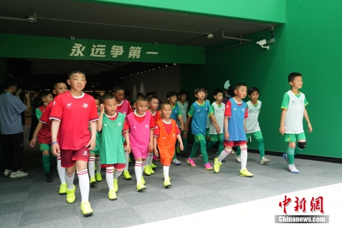 图为国安小球员和青海玉树的藏族少年们一起走进球场。中新社记者 崔楠 摄